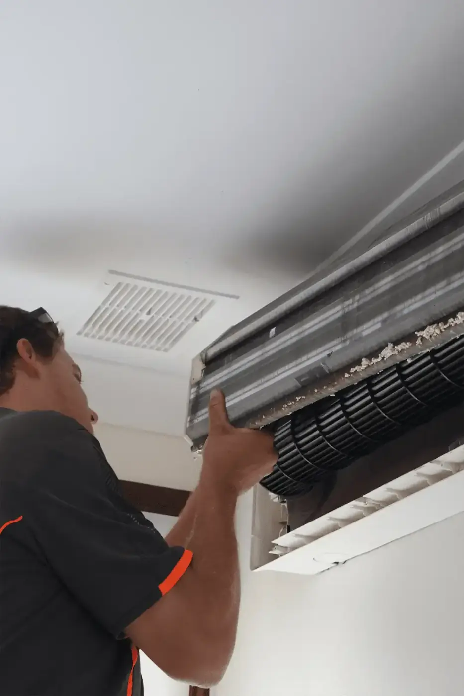 Technician performing maintenance on a split system indoors