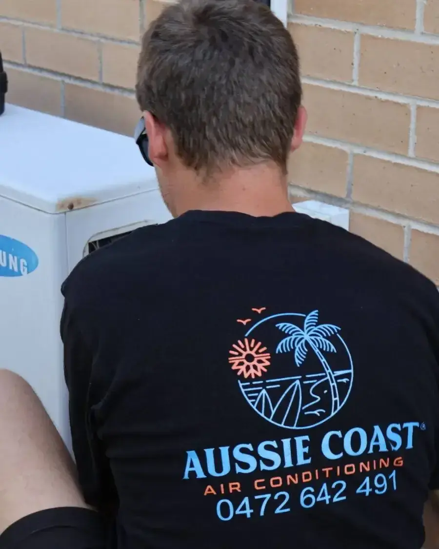 Aussie Coast technician working on an air conditioning unit