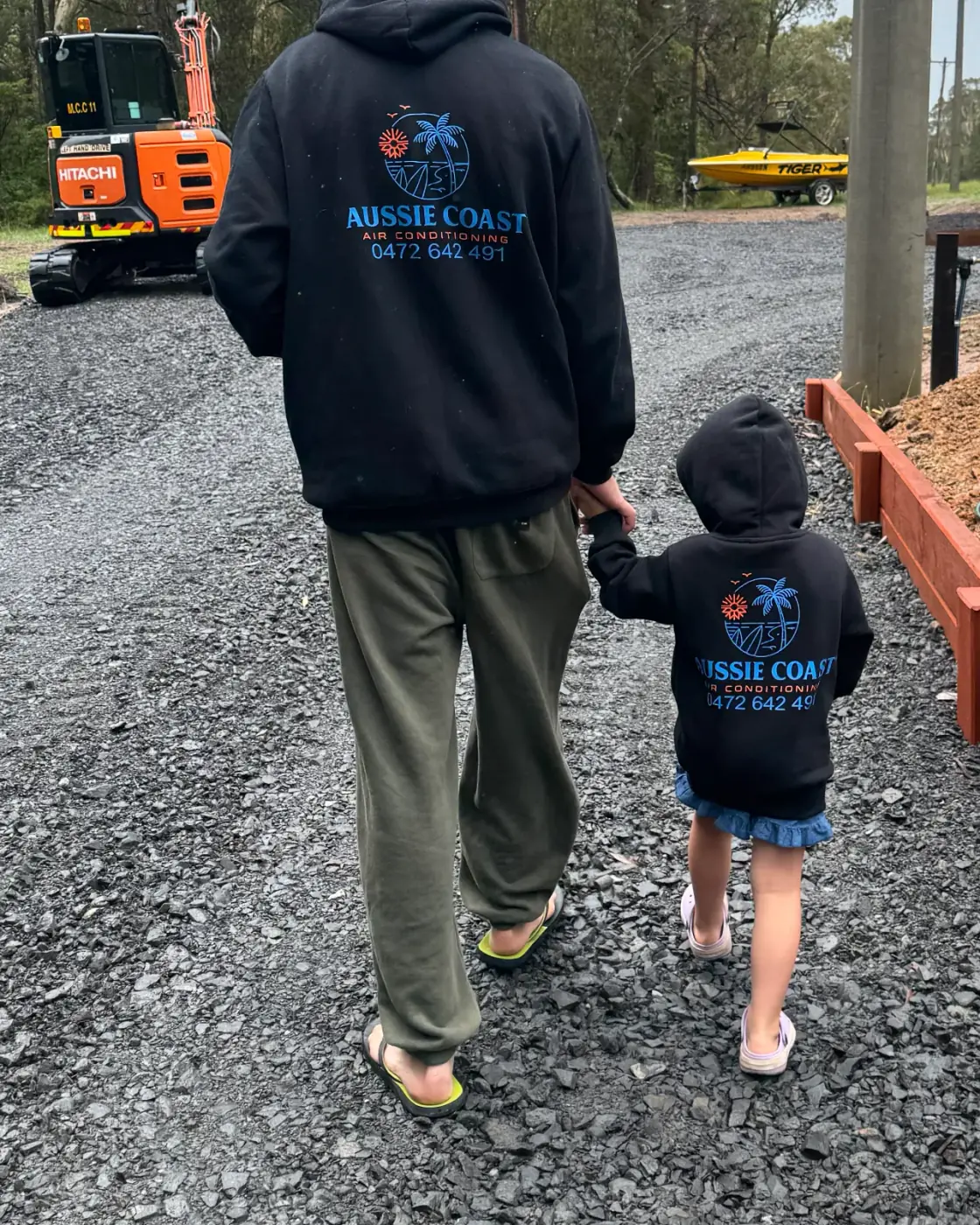 Aussie Coast Air Conditioning owner and his daughter walking together in matching Aussie Coast hoodies