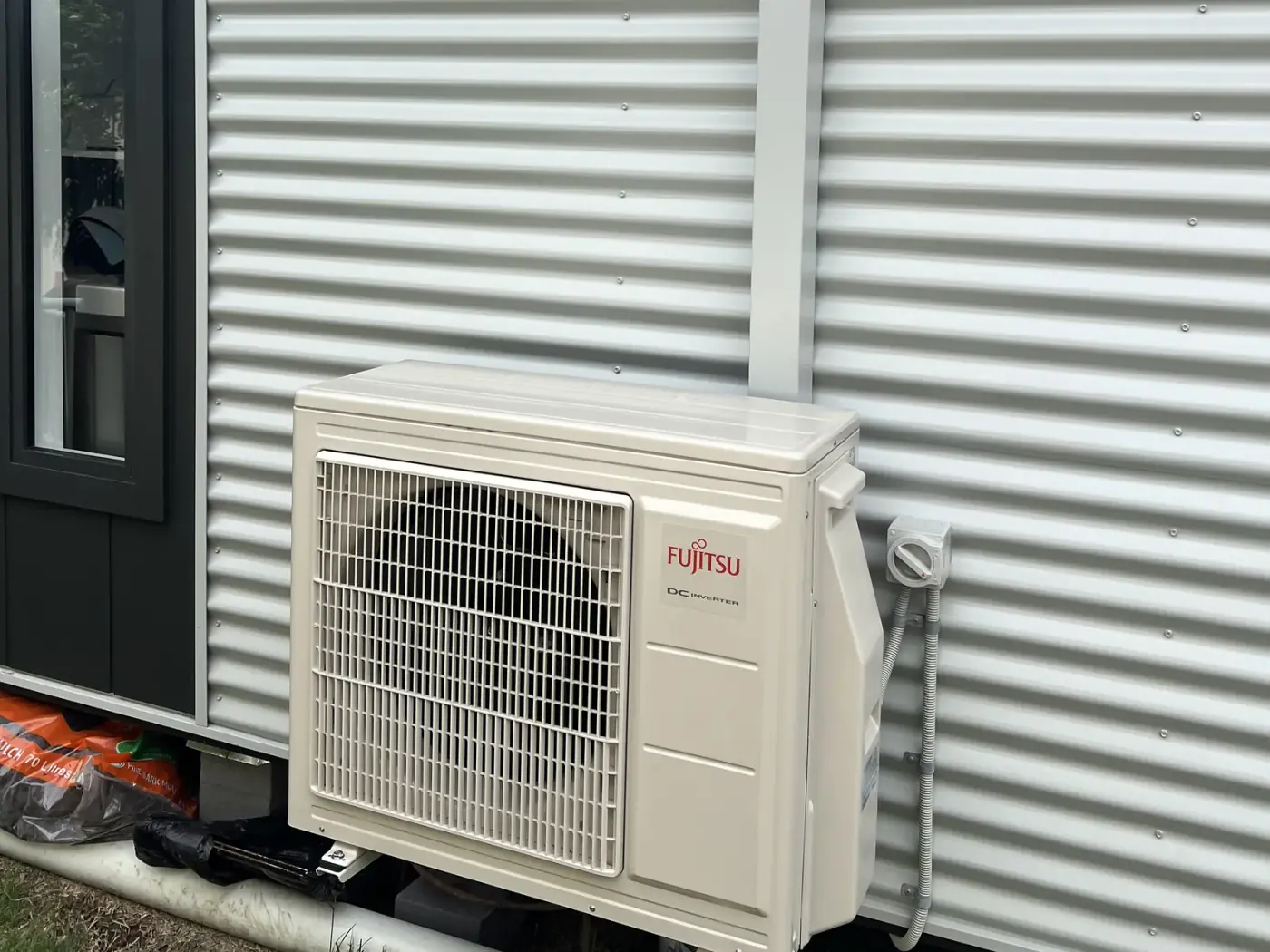 Fujitsu split system outdoor unit installed with a neat pipe cover on a Jervis Bay home
