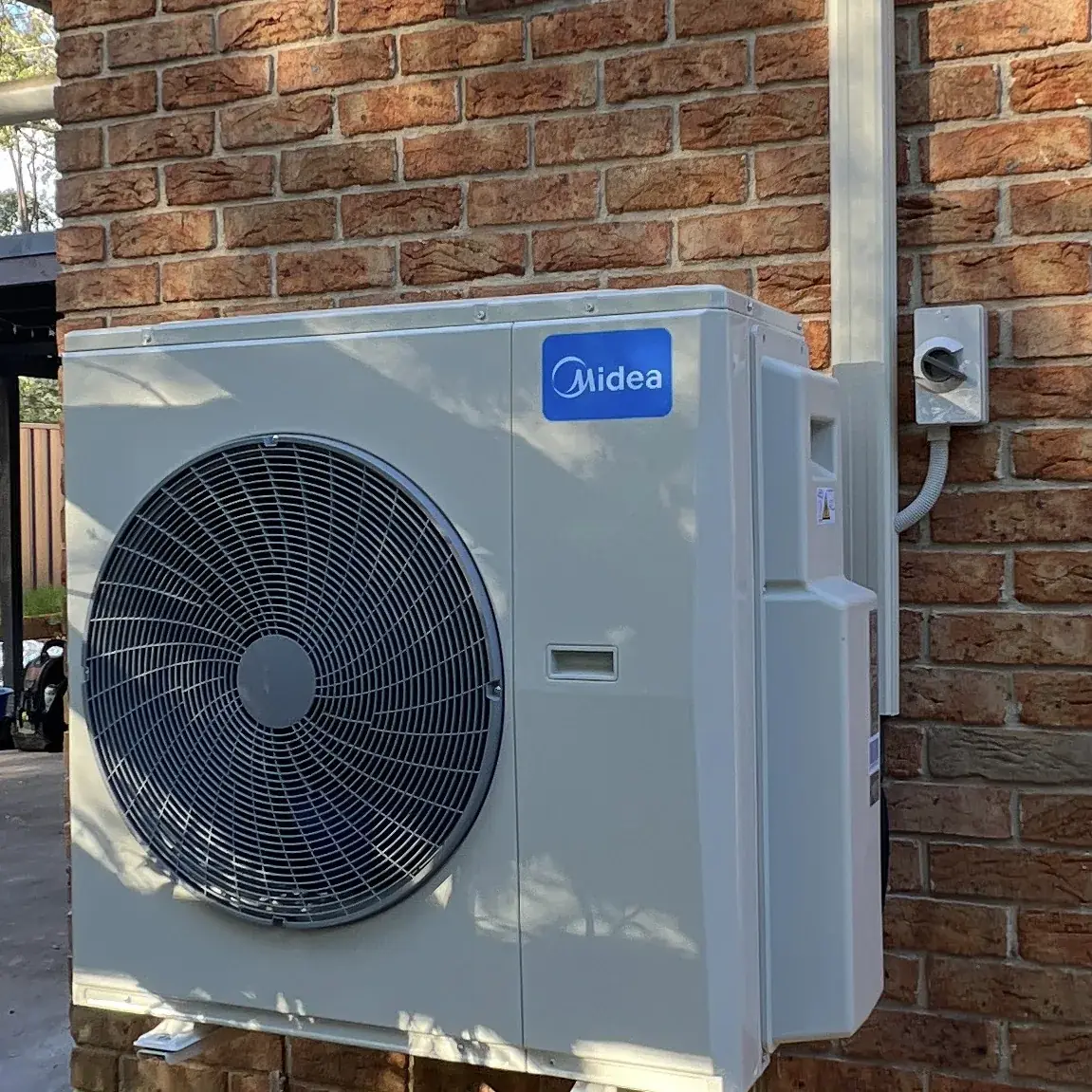 Midea split system outdoor unit installed on a brick home near Ulladulla