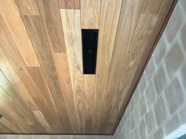 Custom black baby linear slot outlet set into a timber ceiling