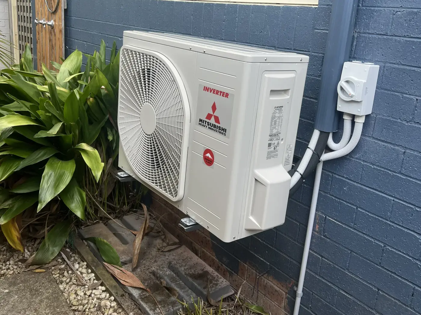 Mitsubishi Heavy Industries split system outdoor unit wall-mounted with pipe cover on a Nowra home